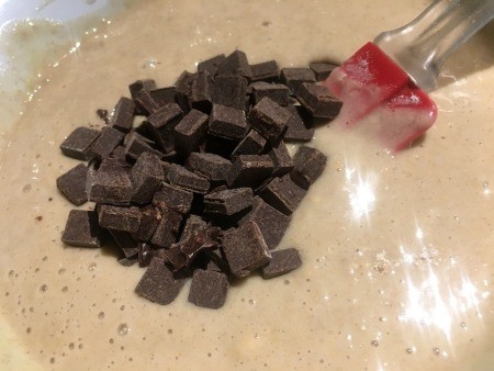 Adding chocolate chunks to the batter.