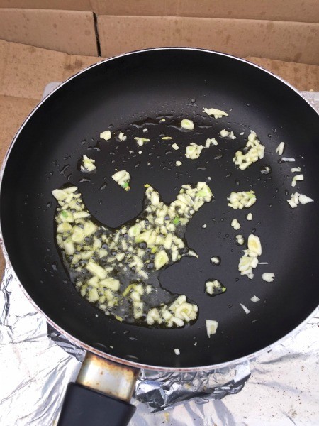 Sauteing garlic in a frying pan.