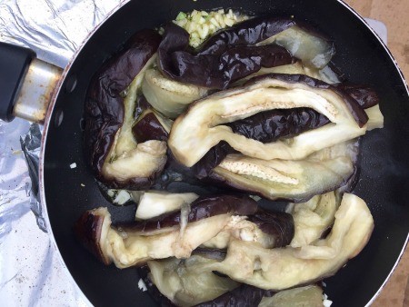 Sauteing eggplant in a frying pan.