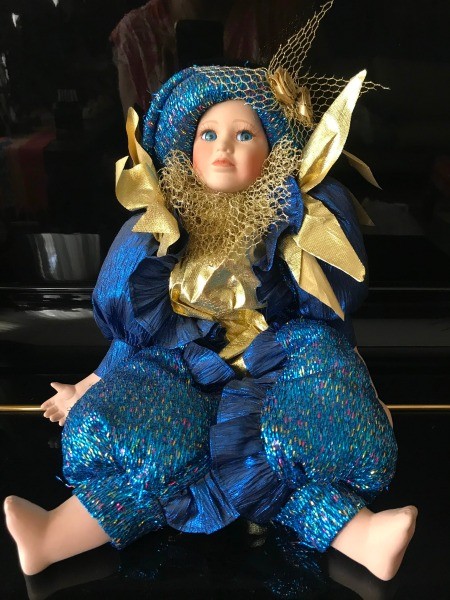 A porcelain doll in a blue costume.