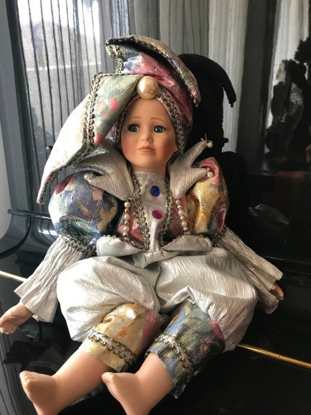 A porcelain doll with an ornate costume.