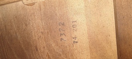 Numbers marked on the back of a wood dresser.