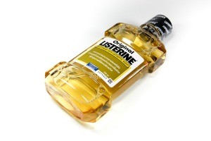 A bottle of amber Listerine on a white backgroun.