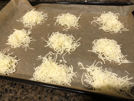 Heaps of shredded mozzarella parmesan on a cookie sheet.