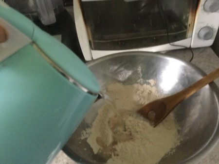 Adding hot water to the pie crust mixture.