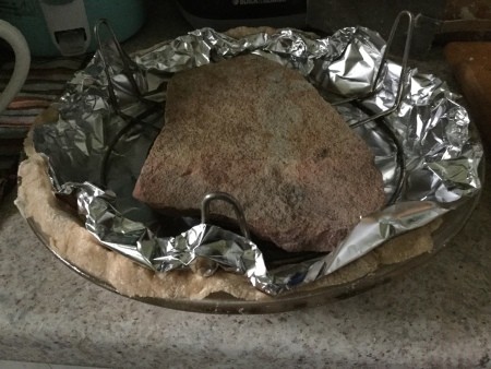 A rock weighing down a pie crust for prebaking.