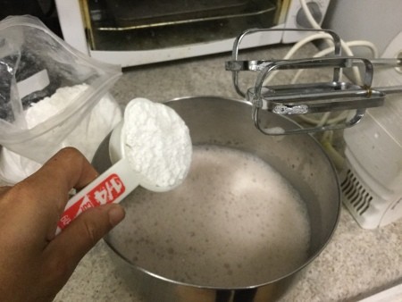 Adding corn starch to the meringue mixture.