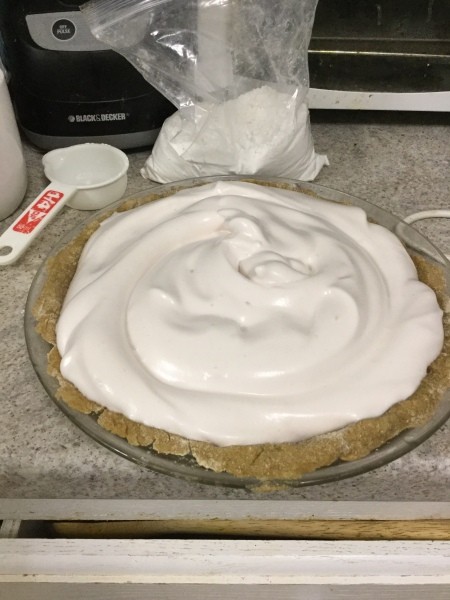Topping the pie with meringue before baking.