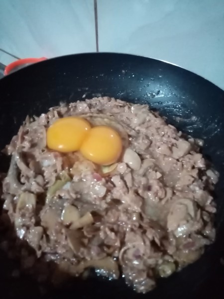 Adding eggs to the pan.