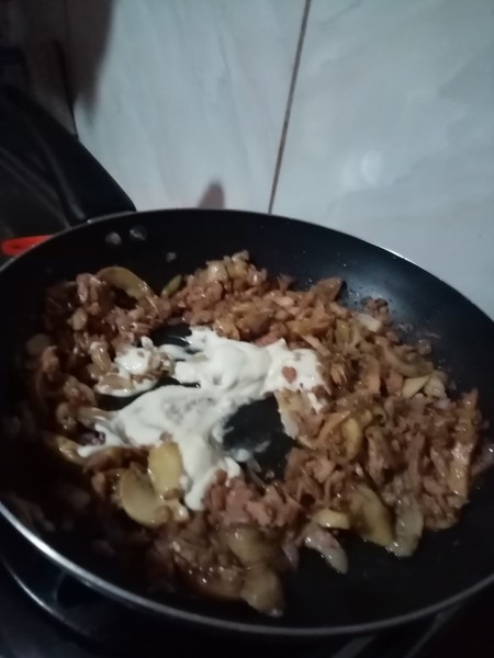 Adding mayonnaise to the pan.