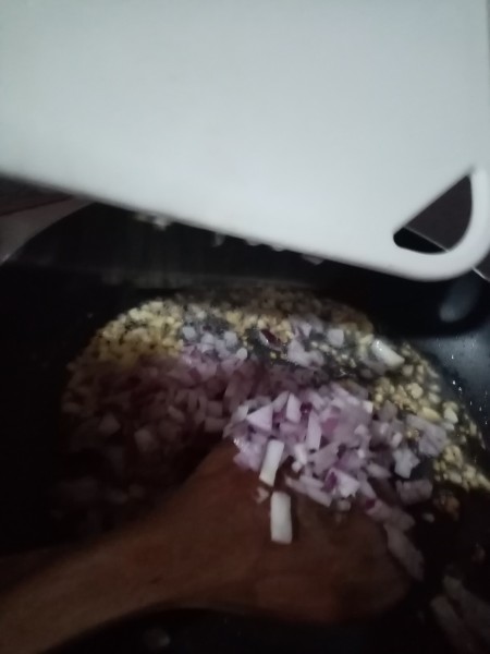 Adding finely chopped shallots to the pan.