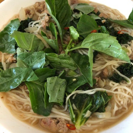 Basil added to the pork noodle soup.