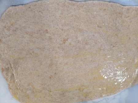 The egg mixture brushed on the rolled out dough.