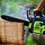 A chainsaw cutting of a plank from a log.