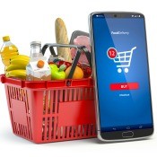 A basket of groceries next to a smartphone.