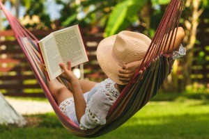 A woman reading in a hammock.