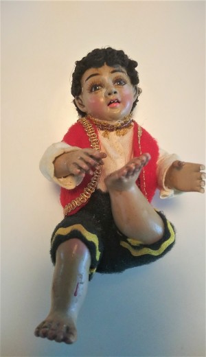 Identifying a Porcelain Figurine? - sitting figurine of a boy with foot up and wearing gold trimmed red vest
