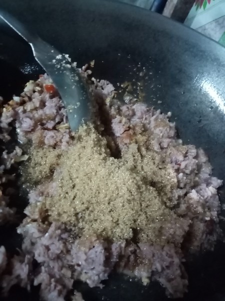 Adding sugar to the mixture.