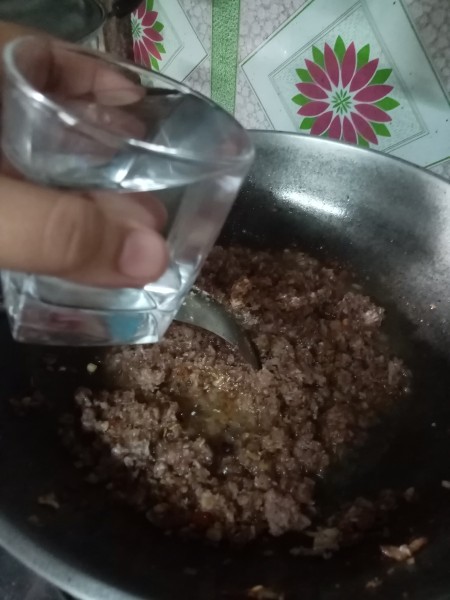 Adding water to the mixture.