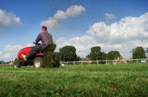 A man on a riding lawnmower.