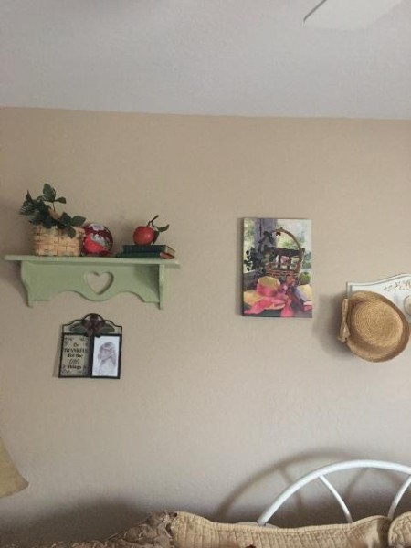 A shelf and hat on a wall.