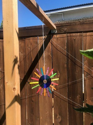 Hanging CD Reflective Garden Decoration - multicolored one hanging outside from a 4x4