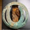Identifying an Old Equipment Emblem? - corroded circle with horseshoe emblem or? with a rusty mount on the back