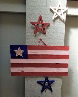 A wooden stick flag with wooden stars in red, white and blue.
