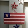 A wooden stick flag with wooden stars in red, white and blue.