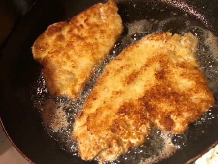 Frying the breaded cutlets in a pan.