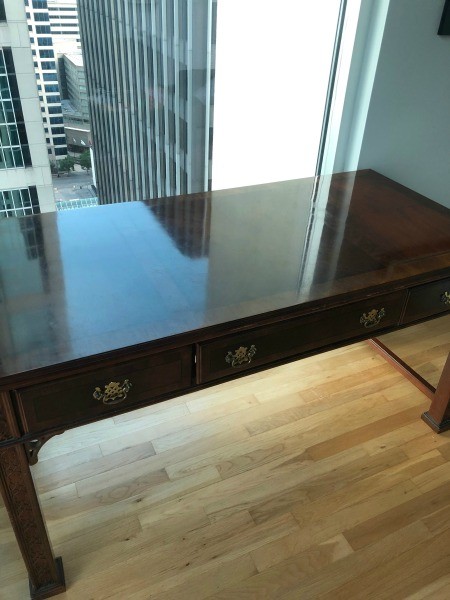 The glossy top of a wooden desk.