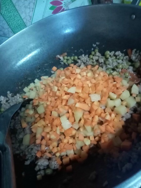 Adding ingredients into a frying pan.