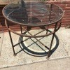 A wrought iron table with a glass top.