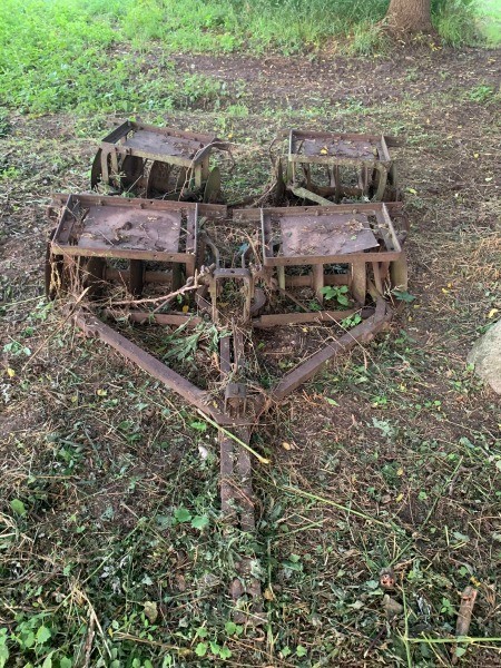 A rusty piece of farm equipment in a field.