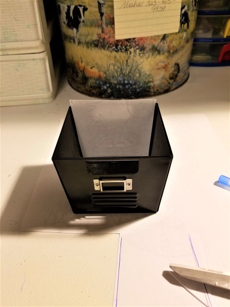 A metal box holding scraps of paper.