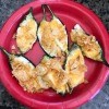 A finished plate of jalapeño poppers, topped with potato chips.