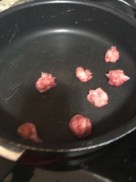 Cooking pieces of sausage in a frying pan.