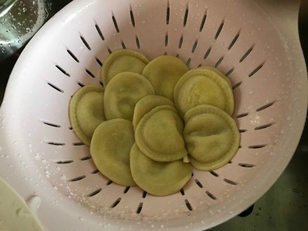 Cooked tortellini in a colander.