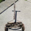 A old reel mower on a concrete surface.
