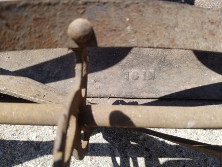 A close up of the blades on an old metal reel mower.