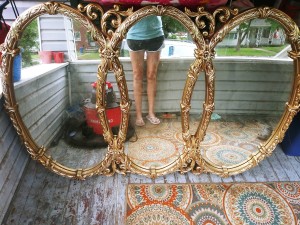 A three panel mirror with a gilt frame.