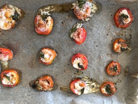 A sheet of baked tomatoes with mozzarella.