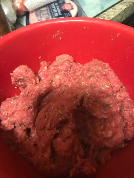 Ground beef mixed with spices to make meatloaf.