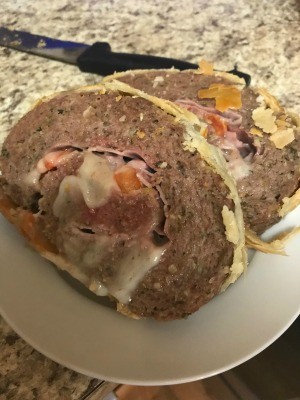 Two slices of stuffed meatloaf on a plate.