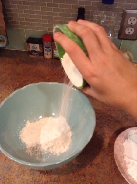 Adding flour to a bowl.