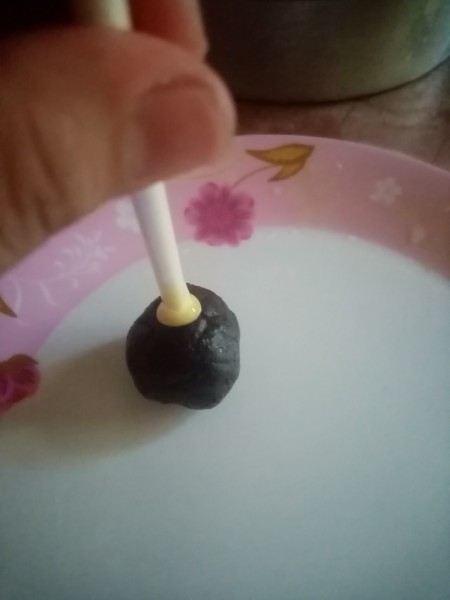 Attaching the cake pop to a stick.