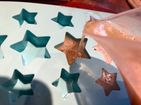 Pouring the gelatin mixture into a silicone tray.