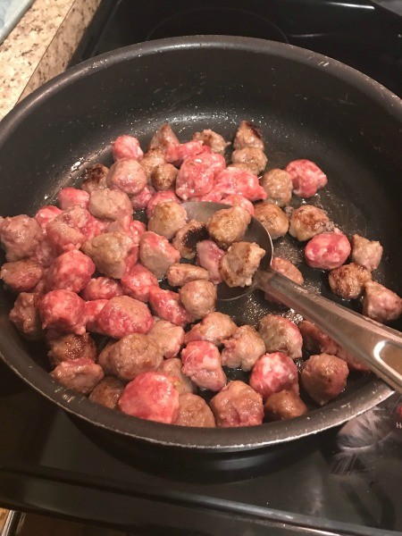 Sausage being cooked in a pan.
