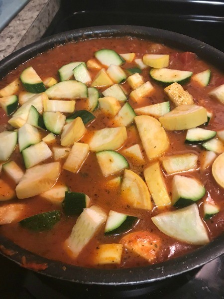Vegetables and canned tomatoes being cooked together.