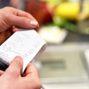 A woman looking at her shopping receipt.